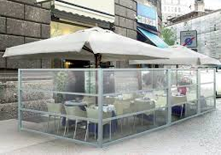 glass wall dividers around an outdoor seating area at a cafe